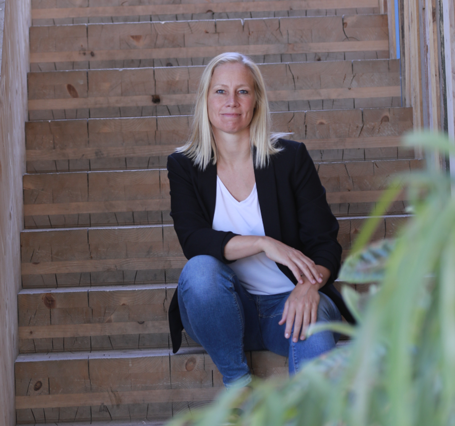 Ergoterapeut Anja Larsen sidder på smuk naturtrappe imødekommende og klar til at snakke